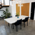 White concrete dining room table with brushed stainless steel base